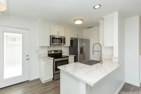 a kitchen with appliances a sink cabinets and wooden floor