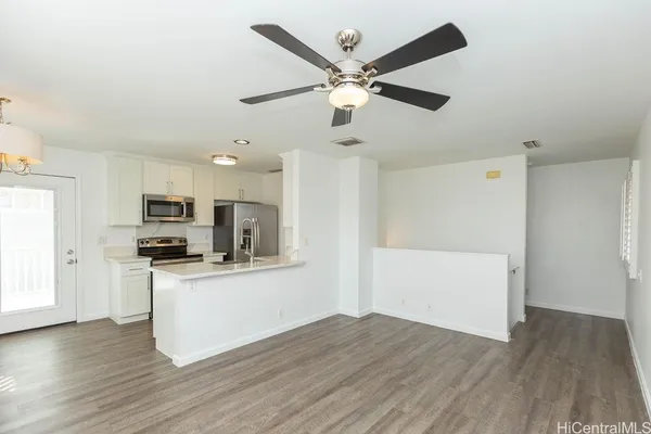 a kitchen with granite countertop a refrigerator and a stove top oven