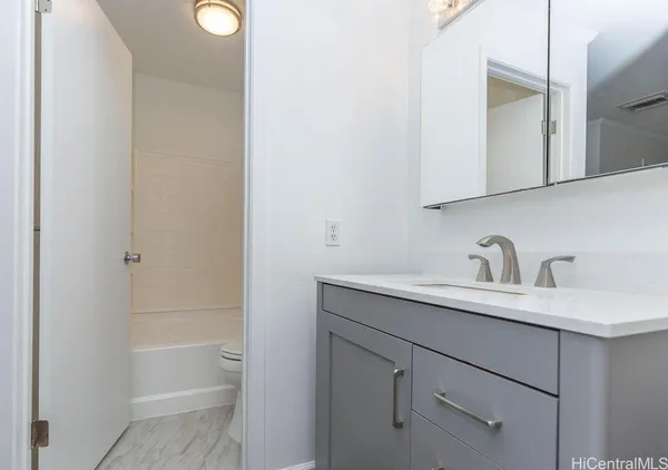 a bathroom with a granite countertop sink and a mirror