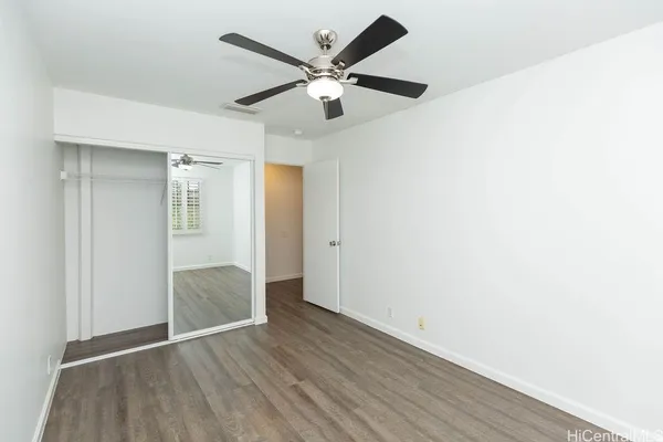 a view of an empty room with wooden floor