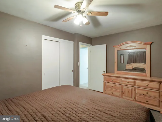 a bedroom with a bed and a dresser with mirror