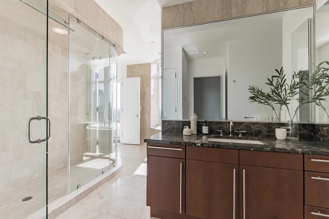 240 Riverside Boulevard, Unit SUITE1 Manhattan, NY 10069 - Photo 18 of 33 a bathroom with a granite countertop sink mirror and a shower