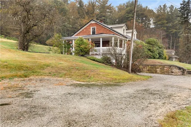 a front view of a house with a yard and trees