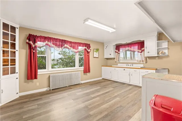 a kitchen with a stove a sink and wooden floor
