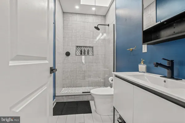 a bathroom with a sink a toilet and shower