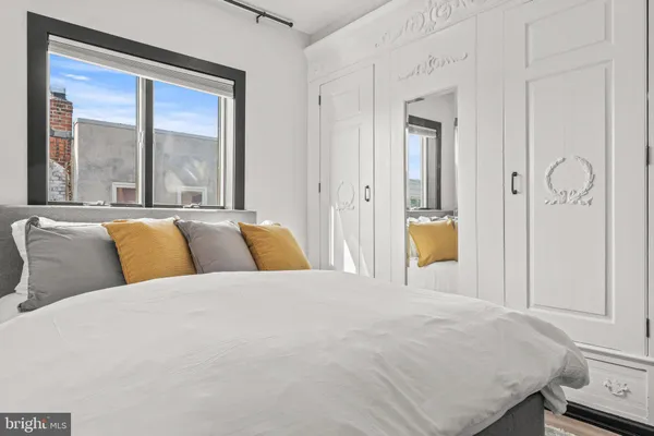 a bedroom with a bed and a large window