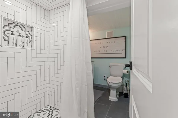 a bathroom with a toilet and a shower curtain