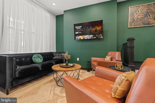 a living room with furniture and a painting on the wall