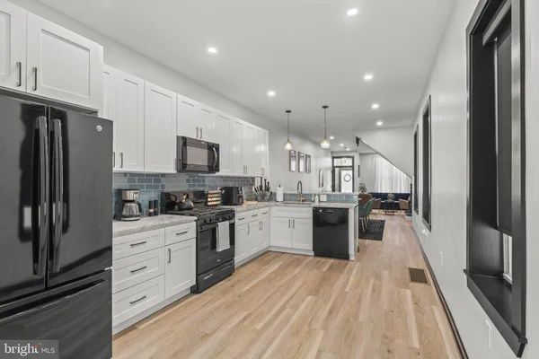 a large kitchen with cabinets wooden floor and stainless steel appliances