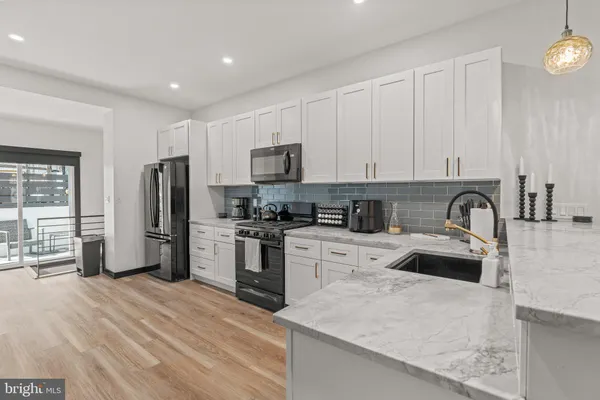 a kitchen with granite countertop a refrigerator stove and sink