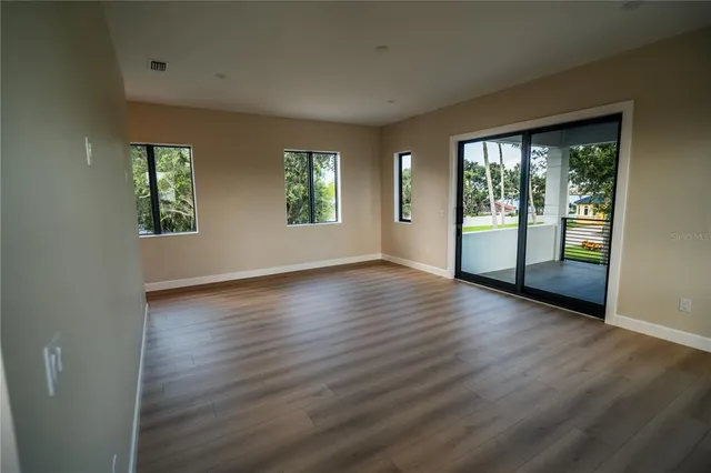 a view of a room with wooden floor and a window