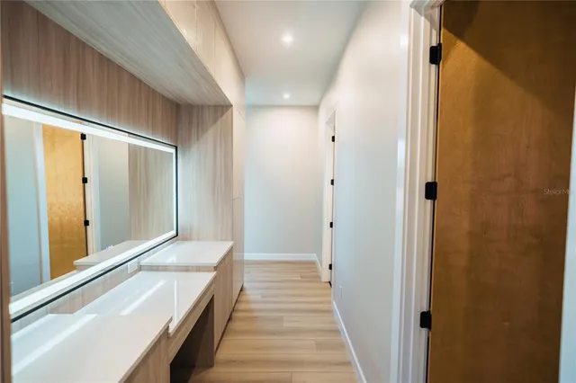 a view of a hallway with wooden floor and staircase