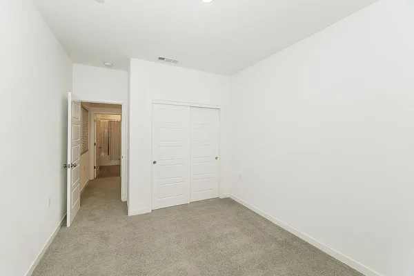 an empty room with windows and fan view