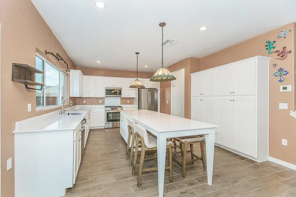 a kitchen with a refrigerator stove and white cabinets