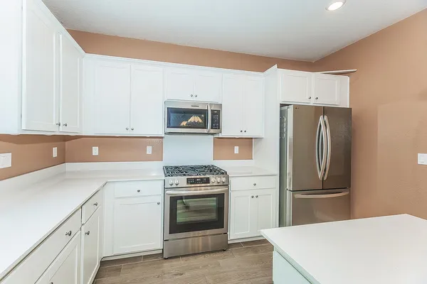 a kitchen with stainless steel appliances a stove microwave and cabinets