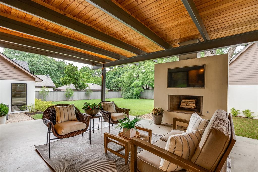 4325 Pomona Road Dallas, TX 75209 - Photo 21 of 23 Expansive covered patio featuring a concrete floor, wood-plank ceiling, and a built-in outdoor fireplace with an integrated media niche