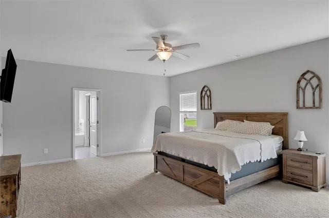 a bedroom with a bed chandelier painting on the wall and a window