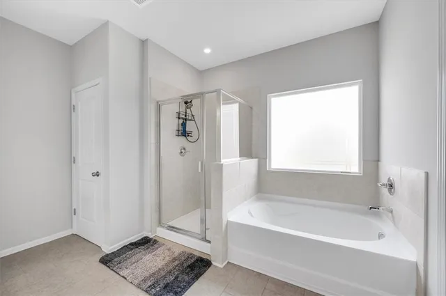 a spacious bathroom with a bathtub and a shower