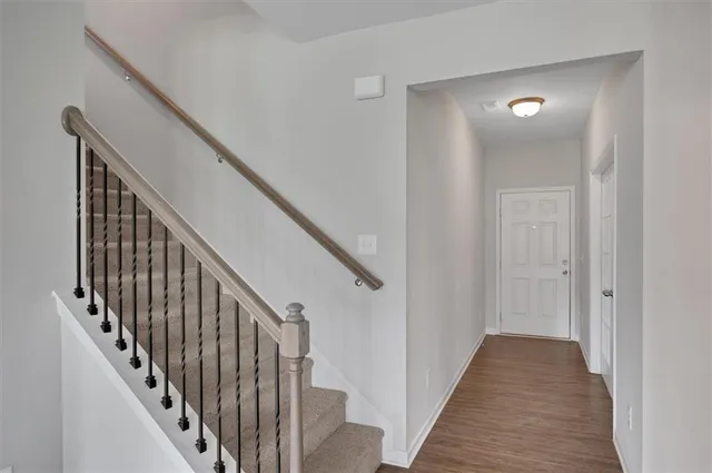 a view of a hallway with wooden floor and stairs