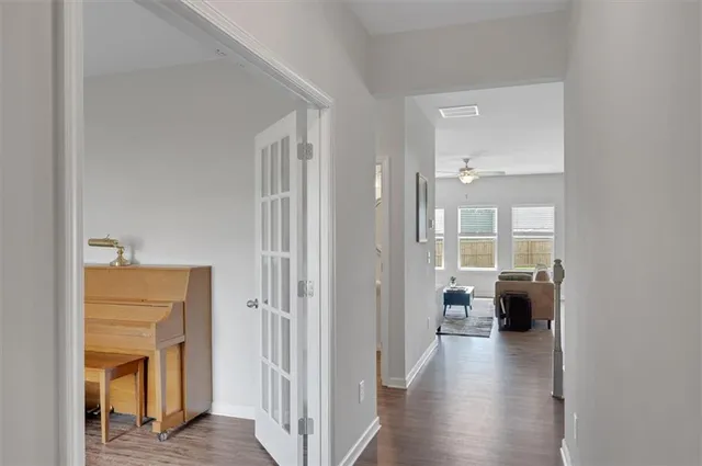 a view of a hallway with toilet and wooden floor
