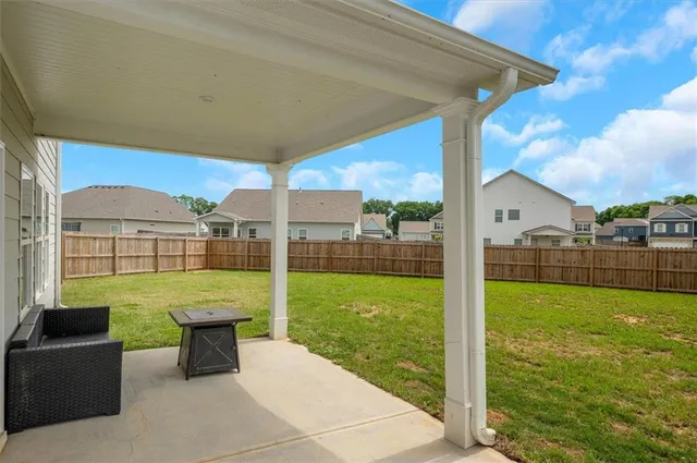 a view of a backyard with plants and outdoor seating