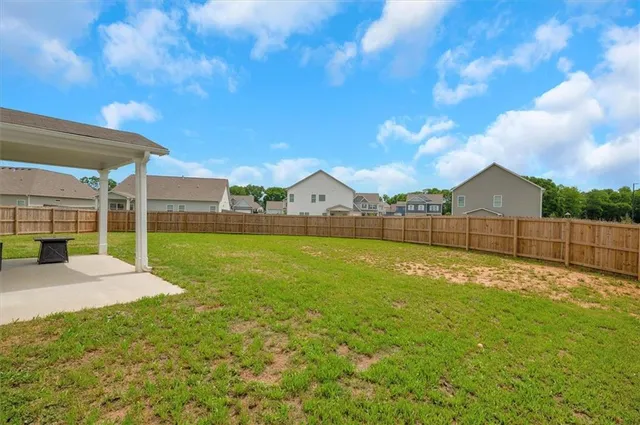 a view of backyard with table and chairs and wooden fence