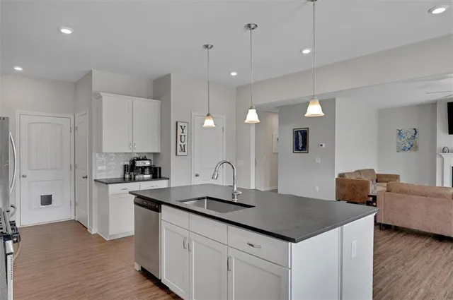 a kitchen with stainless steel appliances granite countertop a sink a stove and a refrigerator