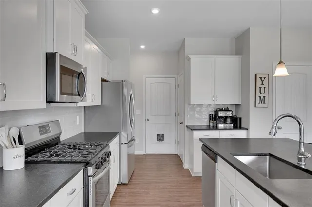 a kitchen with stainless steel appliances granite countertop a sink stove and refrigerator