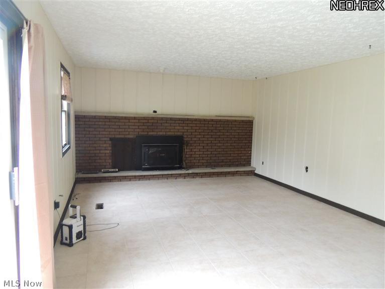 3650 Newton Falls Bailey Road Warren, OH 44481 - Photo 8 of 18 Newly tiled floor with a full wall fireplace.