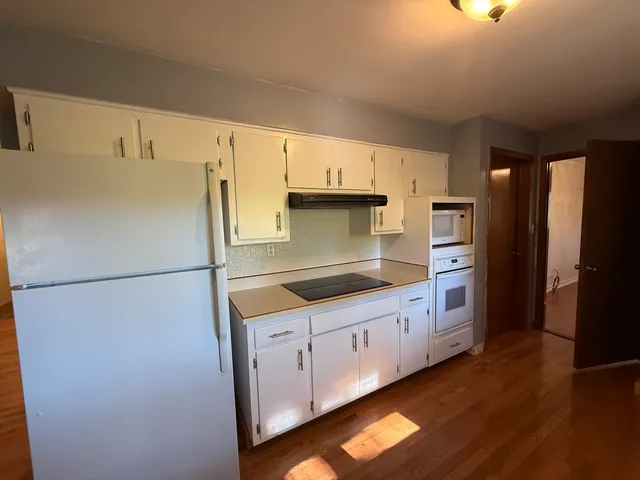 a kitchen with granite countertop a refrigerator a sink and dishwasher