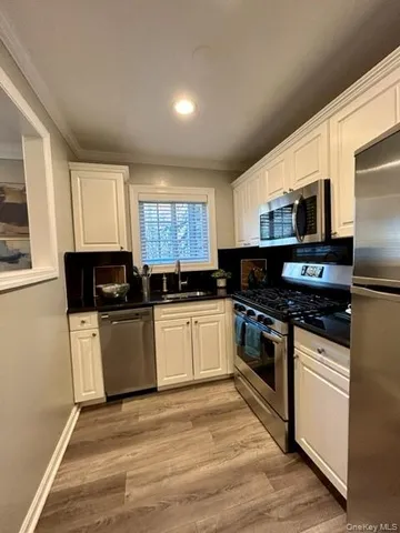 a kitchen with granite countertop a refrigerator stove top oven and sink