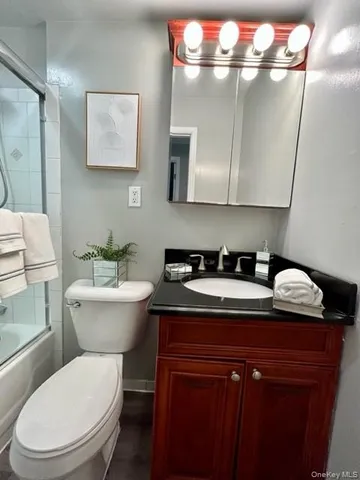 a bathroom with a granite countertop sink a toilet and a mirror