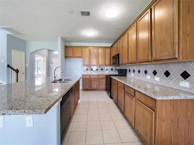 a large kitchen with stainless steel appliances granite countertop a sink counter space cabinets and a large window