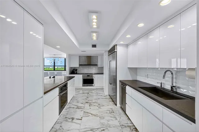 a large kitchen with stainless steel appliances granite countertop a sink and cabinets