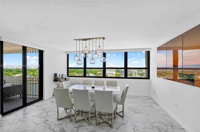 a view of a dining room with furniture large windows and a chandelier