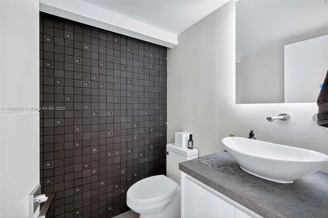 a bathroom with a sink toilet double vanity and shower