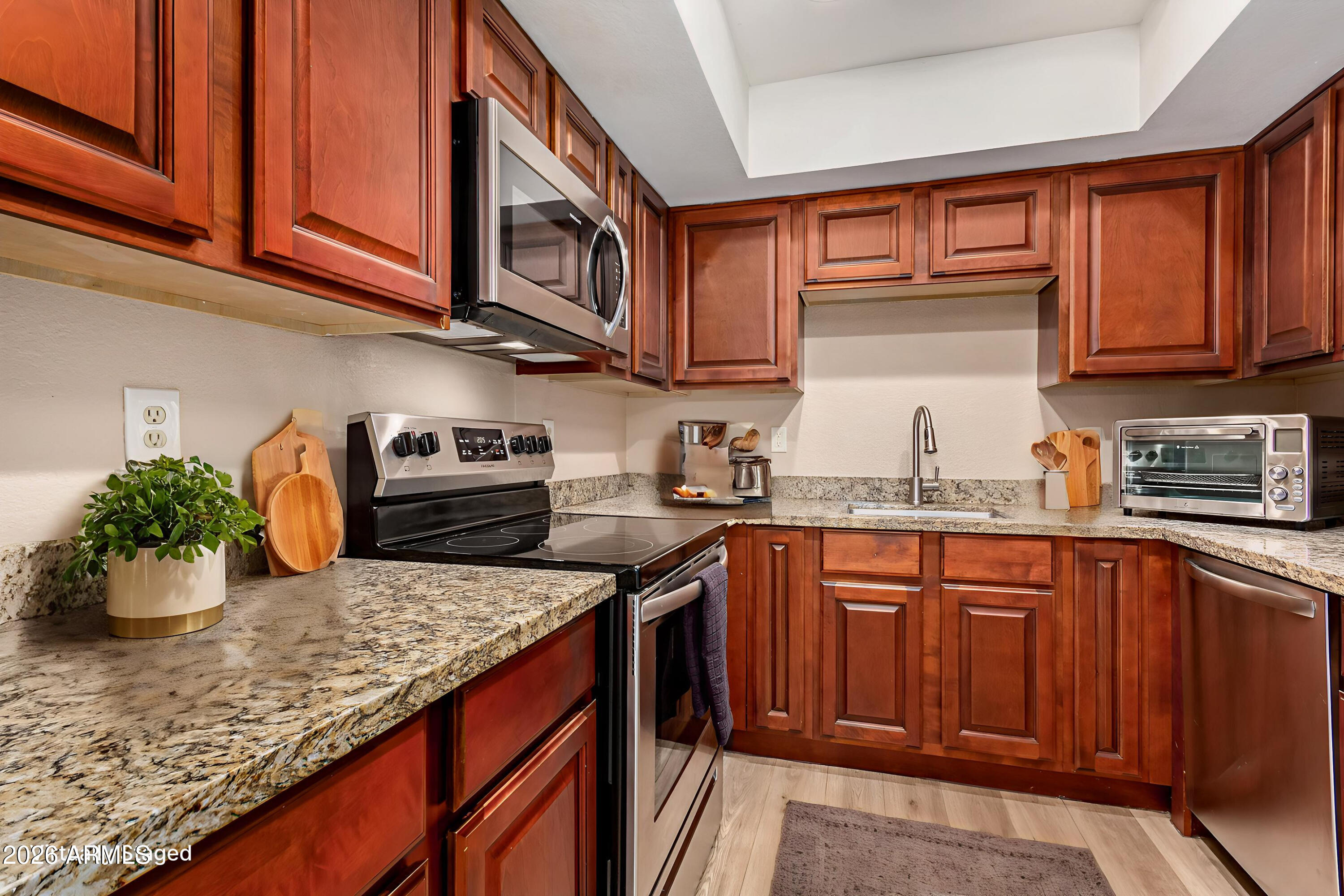 1340 North Recker Road, Unit 343 Mesa, AZ 85205 - Photo 10 of 28 a kitchen with stainless steel appliances granite countertop a sink dishwasher stove and cabinets