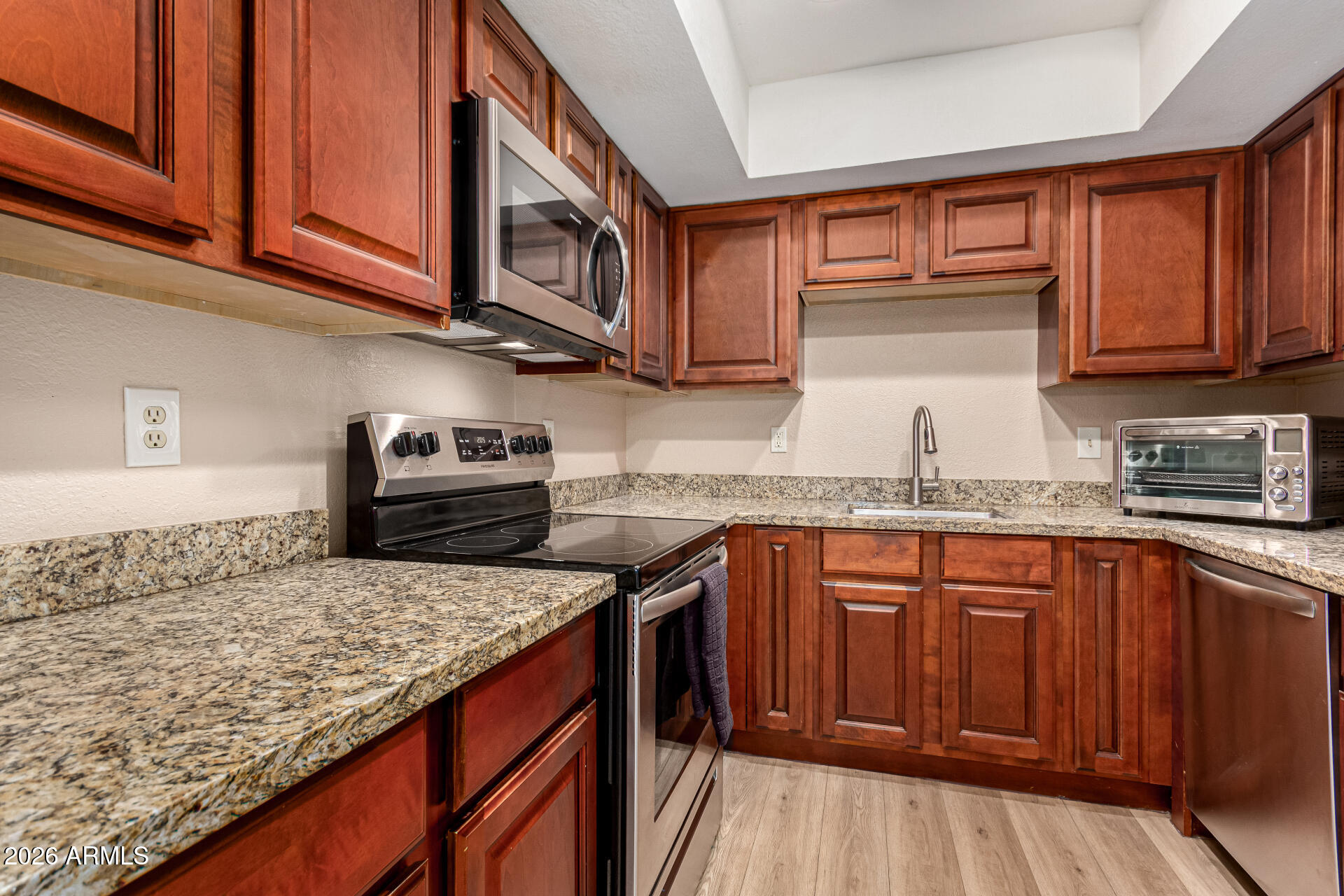 1340 North Recker Road, Unit 343 Mesa, AZ 85205 - Photo 11 of 28 a kitchen with stainless steel appliances granite countertop a sink stove microwave and cabinets