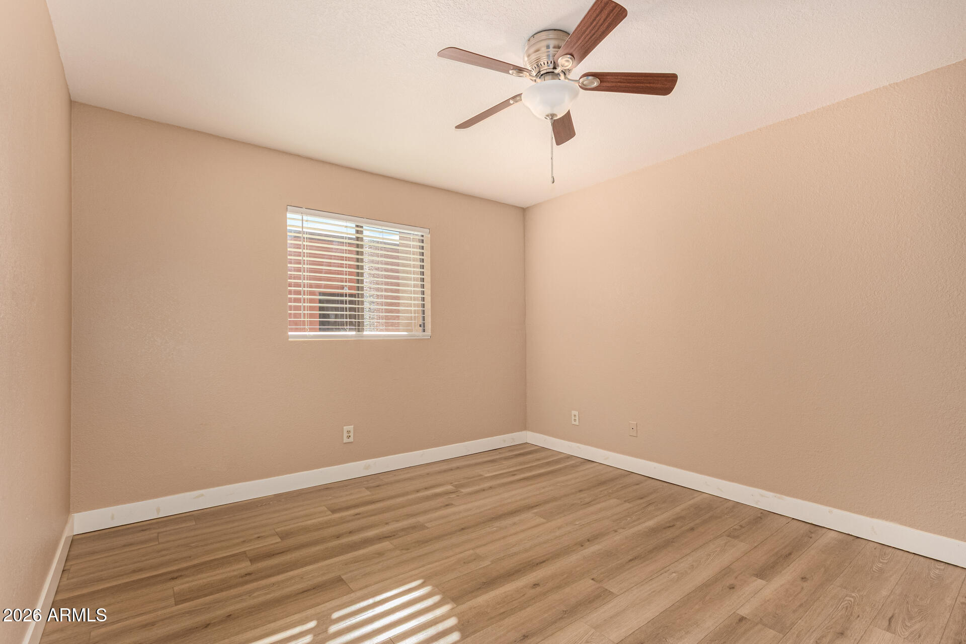 1340 North Recker Road, Unit 343 Mesa, AZ 85205 - Photo 14 of 28 an empty room with wooden floor fan and windows