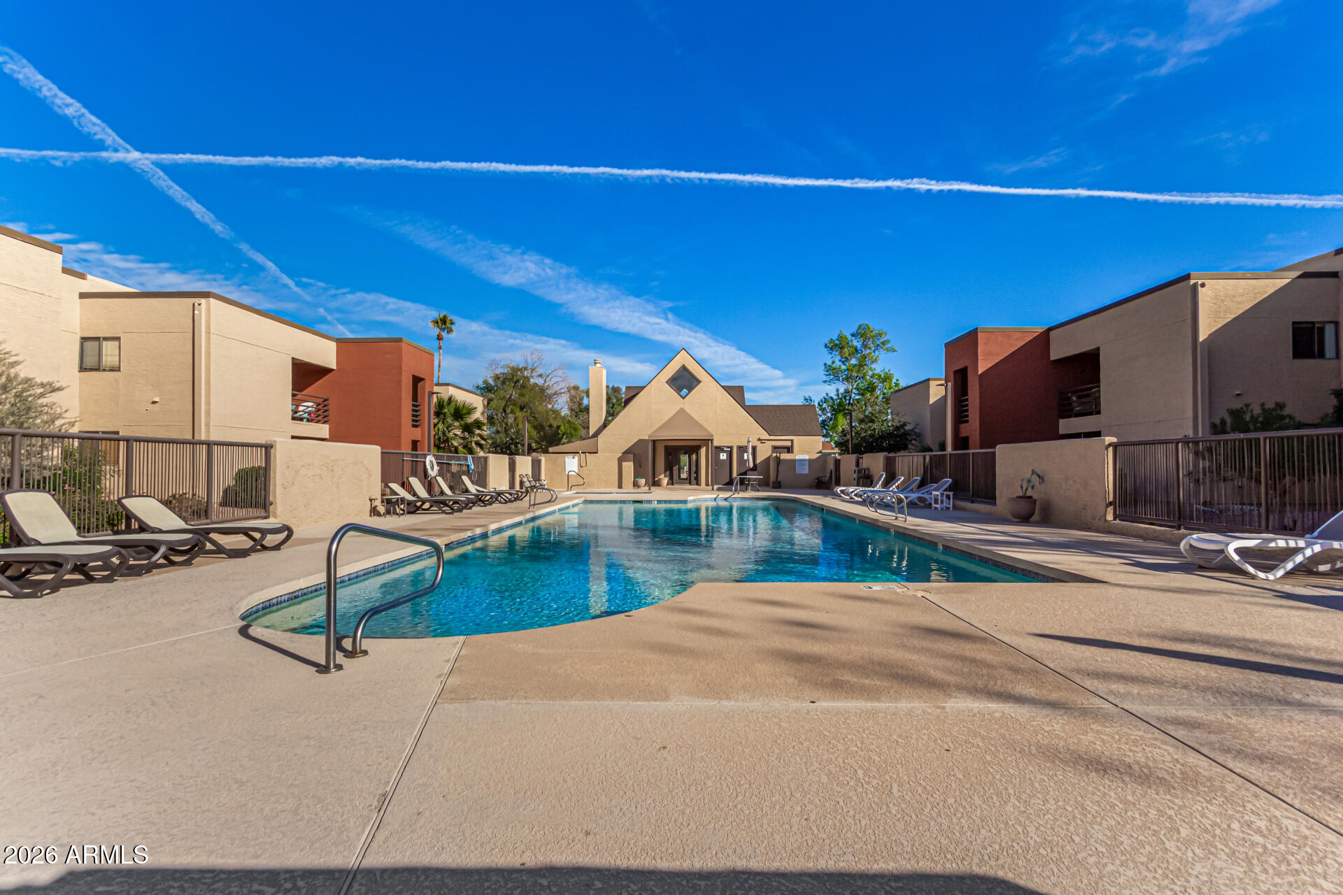 1340 North Recker Road, Unit 343 Mesa, AZ 85205 - Photo 25 of 28 a view of a swimming pool with a chairs and plants
