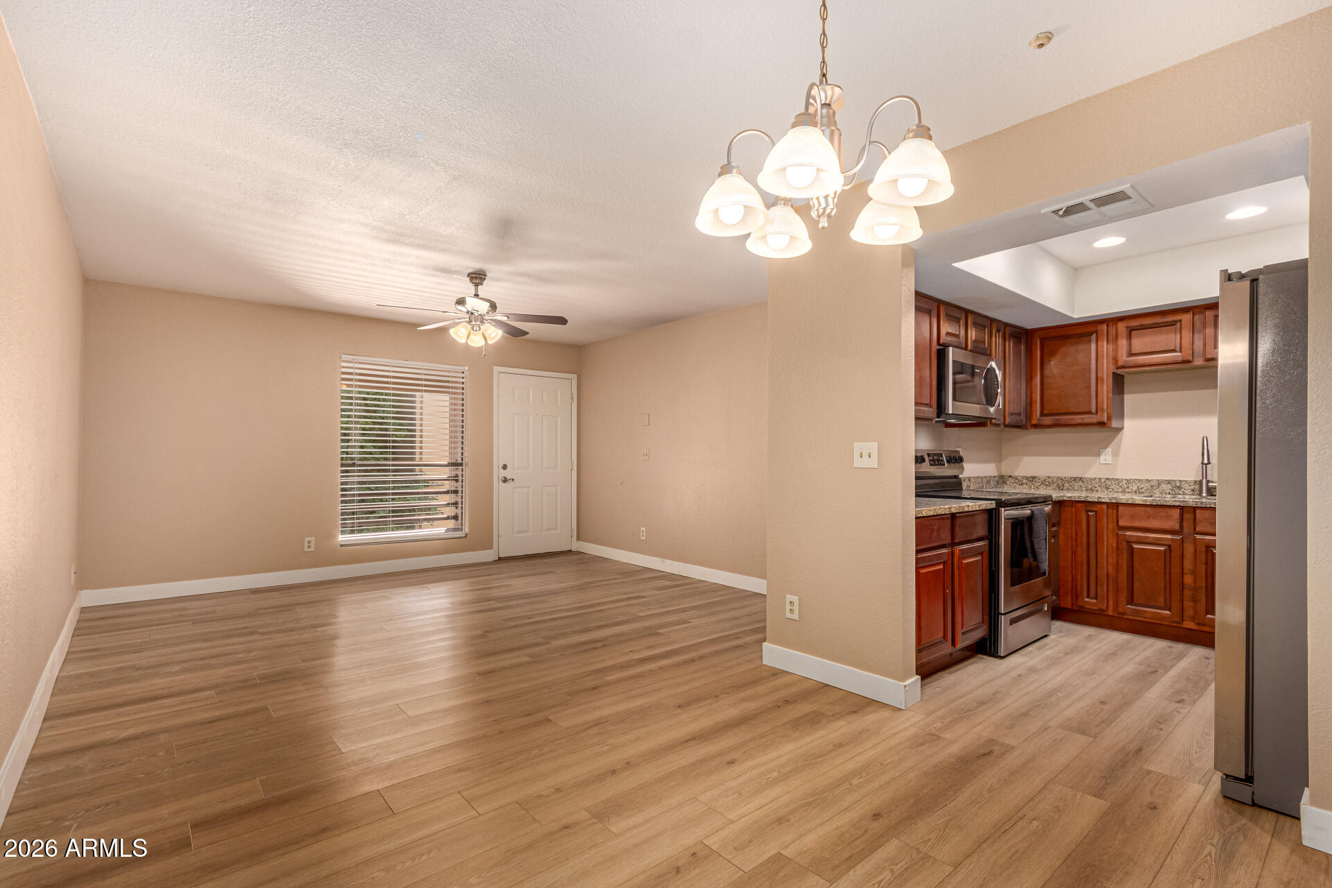 1340 North Recker Road, Unit 343 Mesa, AZ 85205 - Photo 9 of 28 a view of a kitchen with a sink a kitchen island wooden floor and a window