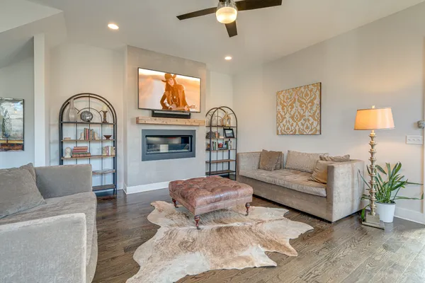 a living room with furniture a ceiling fan and a flat screen tv