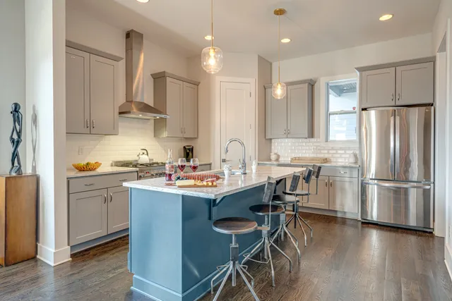 a kitchen with a sink a refrigerator and wooden floor