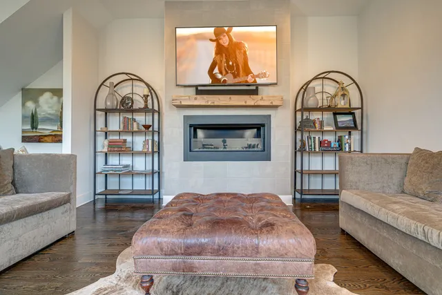 a kitchen with stainless steel appliances granite countertop a stove top oven a sink dishwasher white cabinets and a dining table with wooden floor