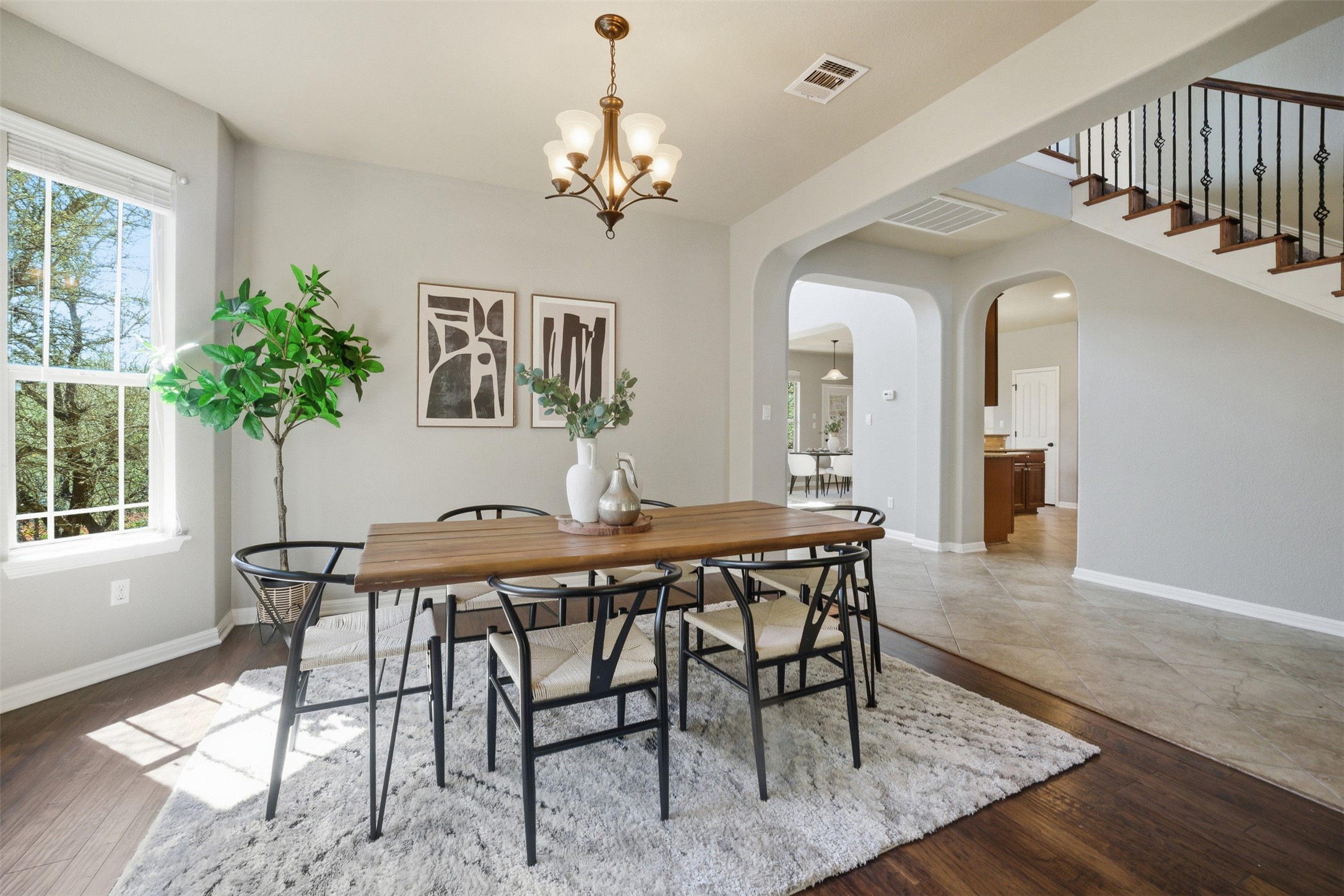 16100 Spillman Ranch Loop Austin, TX 78738 - Photo 9 of 39 Dining space featuring arched walkways, a chandelier, and dark wood finished floors