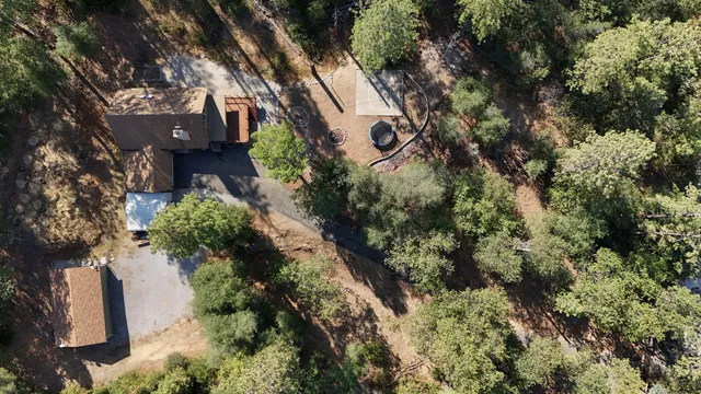 an aerial view of house with yard and mountain view in back
