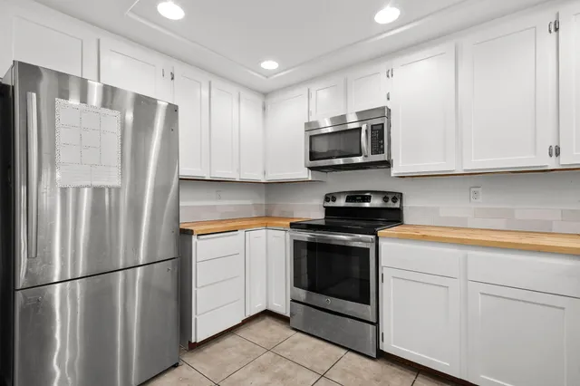 a kitchen with stainless steel appliances granite countertop a refrigerator stove a sink and microwave