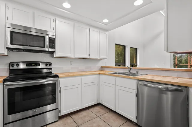 a kitchen with stainless steel appliances granite countertop a stove microwave and sink