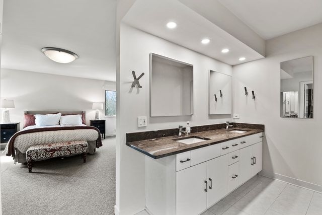 a spacious bathroom with a granite countertop sink and a mirror