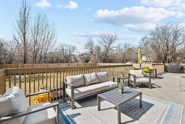 a roof deck with couches and wooden fence